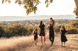 © Cavan Images - happy family Three daughters dad mom walk in the countryside in nature