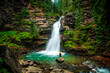 © Cavan Images - Woman at Hidden Waterfall in the Forests of Colorado