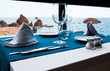 Table with blue cloth and served dishes in restaurant at seaside. Romantic date by the sea.