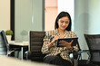 © Prathankarnpap - Modern young businesswoman sitting on office chair and using digital tablet. Business, people and technology