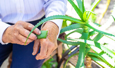 Old woman treated with aloe vera juice. Selective focus.