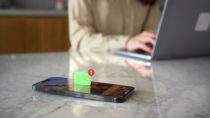 Wall Mural - Receiving text message on mobile smart phone, animated envelope icon with woman working on her laptop at background. Emergency phone notification
