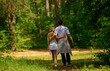 © serhii - man and woman walking in the forest full length back view