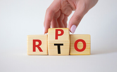 RPO vs RTO symbol. Businessman hand turns wooden cubes and changes the word RTO to RPO. Beautiful white background. business concept. Copy space