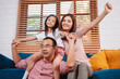 © Kiattisak - Happy asian family enjoying weekend time relax on couch playing together at home.