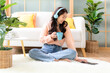 © freebird7977 - Home lifestyle woman relaxing lying down in living room. Happy girl shopping and listen music on laptop for wellness and health in weekend holiday.  Lifestyle Concept