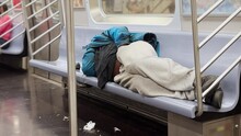 A Homeless Man Sleeps In A Manhattan Subway Car.  	