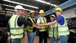 © M Stocker - Team of warehouse workers standing and stacking hands together at old motor automotive parts warehouse. Group of engineers and workers join hands for teamwork. Unity and teamwork concept