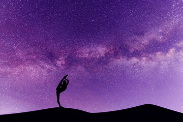 Wall Mural - woman silhouette dancing in the night, on the bright milky way galaxy background.