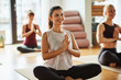 © Flamingo Images - Smiling young woman sitting in a yoga class