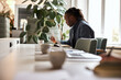 © Flamingo Images - African businessman writing notes at his desk