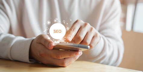 Wall Mural - close up man hand use smartphone for search engine optimization (seo) tools for finding customer or 