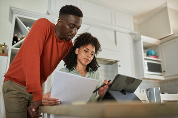 young multiracial couple using a tablet to do their online banking