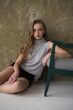 © alipko - Young fashion woman posing near grey wall