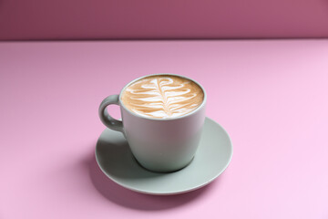 Wall Mural - hot cappuccino with latte art isolated in pink background