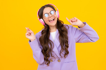 Poster - Amazed teen girl. Teenager in modern wireless headphones enjoying song music in audio app, listening to her favorite music over yellow studio background. Excited expression, cheerful and glad.