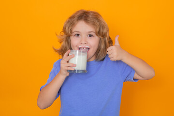 Wall Mural - Healthy drink with calcium and protein for kids. Funny blonde child drinking milk isolated on yellow. Little boy with milk mustache hold glass of milk.