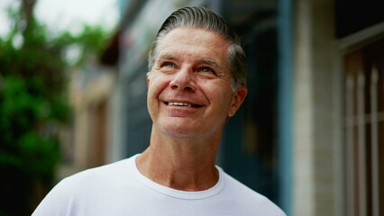 Senior man raising head to sky smiling, Hopeful expression of an older middle-age male caucasian person looking up at sky smiling with GRATITUDE