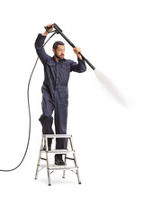 Canvas Print - Man in a uniform using a pressure washer and standing on a ladder