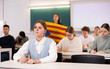 © JackF - Students study in classroom, teacher stands behind with flag of Catalonia
