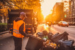 © VisualProduction - Garbage worker collecting trash in urban suburb, cleaning the streets, environmental care. Generative AI