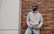© San4ezz007 - City portrait of handsome hipster guy with beard wearing gray blank hoodie or sweatshirt and hat with space for your logo or design. Mockup for print
