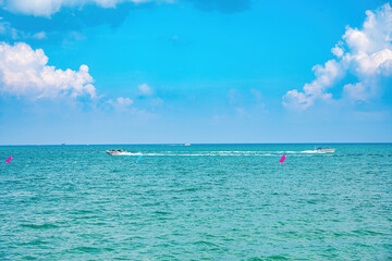 Wall Mural - Beautiful cloudscape over the sea, sunrise shot. Lonely boats. Calm sea with sunset sky and sun through the clouds over. Calm sea with sunset sky or sunrise and sun through the clouds over.