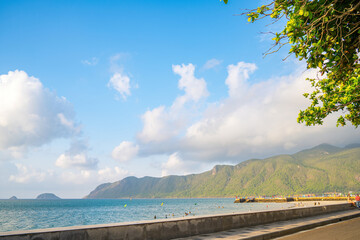 Panoramic coastal Con Dao island view from above, with waves, coastline ,clear sky and road, blue sea and mountain.