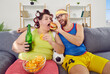 Funny man and chubby fat glutton woman in hair curlers have cheat day together, stop caring about figure and fitness gym workout, sit on sofa, eat unhealthy yummy food try to satisfy insatiable hunger