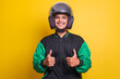 Asian online taxi driver motorbike man wearing helmet and jacket showing thumb up over yellow background