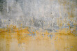 Old cracked vintage yellow cement wall background