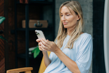 Wall Mural - A woman uses social networks in a mobile phone to communicate.