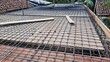 © Diyah - Steel rebar grid and wooden formwork prepared for concrete slab construction on a building site.