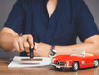 © meeboonstudio - Businessman stamped the approved for car loan agreement while sitting at the table in the office.