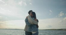 Slow Motion Shoot. Girl Meet Lover Boy At Bank Of River. Couple In Love Happy To See Each Other And Hug Tightly. Young Beautiful Couple Happy To Spend Time Together By Lake In Evening.