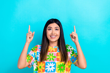 Wall Mural - Photo of cute cheerful lady look direct fingers up empty space toothy smile isolated on teal color background