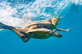 Snorkeling with a sea turtle. Girl swimming with a mask next to the turtle, Maldives