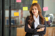 © Wuttichaik - Happy businesswoman planning ideas project work on a glass of wall with colorful memo