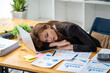 © Wuttichaik - Tired bored exhausted stressed fatigue overwork businesswoman sleeping on tale in office, Burn out saleswoman sleeping in office