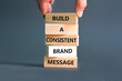 Consistent brand message symbol. Concept words build a consistent brand message on wooden blocks. Businessman hand. Beautiful grey background. Business consistent brand message concept. Copy space.