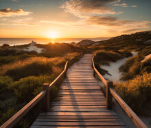 A Wooden Walkway Leads Across The Beach At Sunset