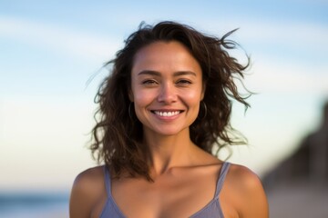 Wall Mural - Portrait of a beautiful young woman smiling at the camera on the beach