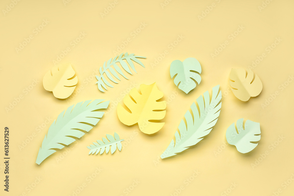 Composition with paper tropical leaves on yellow background