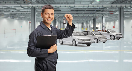 Wall Mural - Auto mechanic holding a clipboard and car keys in a garage with cars