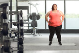 Fototapeta Panele - Overweight in sportswear posing in a gym
