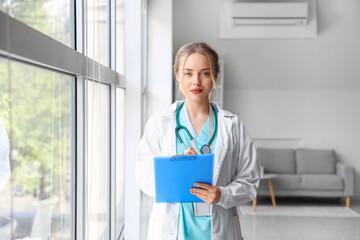 Wall Mural - Female doctor writing in clipboard at hospital