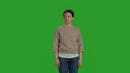Wall Mural - Front view of woman woman showing rejection and pushing something aside, expressing refusal and denial looking displeased. Female model acting discontent moving object, standing over greenscreen.