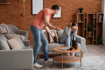 Wall Mural - Scared young woman with her drunk husband at home. Domestic violence concept