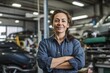Portrait of confident female mechanic standing with arms crossed in auto repair shop