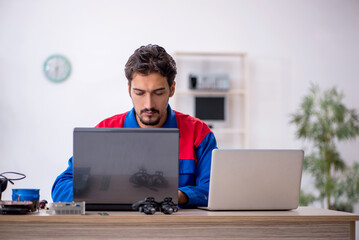 Young male repairman repairing computer